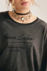 Remera de manga larga gris oscuro con efecto lavado gastado, corte oversize y cuello redondo amplio. Cuenta con estampado tipográfico manuscrito en el pecho.