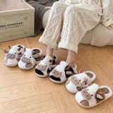 Pantuflas de peluche con diseño de vaca, confeccionadas en piel sintética suave. Cuentan con suela de goma antideslizante y diseño abierto en el talón.