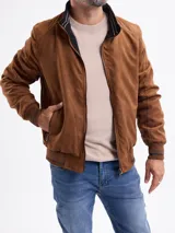 Campera reversible de gamuza sintética color marrón, con cierre frontal, cuello alto y puños de tejido acanalado con detalles de rayas.