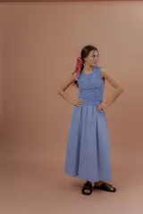 Vestido midi sin mangas de color azul con estampado a cuadros vichy. Presenta la parte superior completamente elastizada y ajustada con efecto fruncido, y falda amplia y suelta.