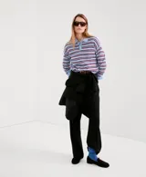 Jersey de punto celeste con rayas horizontales marrones y finas rayas blancas, cuello polo con solapa y cierre frontal de botones cortos, y mangas largas.