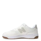 Championes urbanos New Balance de diseño minimalista, color blanco con detalles en beige claro y suela de goma color caramelo.