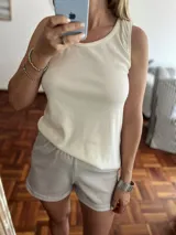 Conjunto de pijama compuesto por musculosa blanca y short gris con lunares blancos.