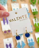 Par de aros colgantes con aro de acero dorado y dije circular azul con borde de strass plateado.