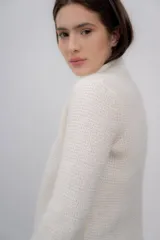 Polera gris de tejido de punto grueso, con cuello alto y mangas largas.