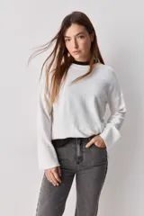 Jean de corte recto en color gris lavado, con detalle de bordados circulares a lo largo de las costuras laterales. Presenta un diseño de tiro medio y calce relajado.