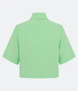 Camisa color verde claro de crepé, con cuello camisero, abotonado delantero, mangas cortas y solapas delanteras aplicadas.