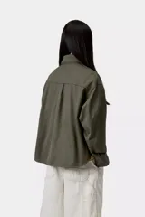 Chaqueta tipo camisa Carhartt WIP modelo Kelly, de color negro, confeccionada en sarga de algodón sin forro. Presenta cierre frontal de botones, bolsillos delanteros en el pecho con solapa, cuello camisero, hombros caídos y una etiqueta cuadrada tejida de la marca.