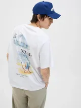 Remera de corte holgado color blanco, con cuello redondo y manga corta. Presenta una estampa artística en la espalda con motivos de playa, sombrilla y silla de descanso.