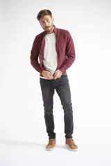 Campera tejida de algodón en color bordó, con cierre frontal completo, cuello levemente elevado y textura acanalada. Presenta puños y ruedo elásticos.