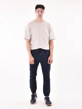 Pantalón jogger de color azul marino, con cordón ajustable en la cintura y puños elásticos en los tobillos.