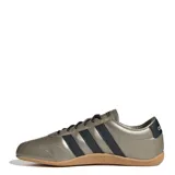 Championes Adidas de estilo urbano, con capellada en tono metalizado bronce, tres tiras laterales en color negro, cordones negros y suela de goma color caramelo.