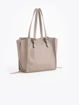 Bolso tipo tote de cuero color tostado con doble asa de hombro, detalles de hebillas metálicas en el frente y cierres laterales decorativos.
