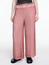 Pantalon de corte amplio y relajado, confeccionado en viscosa con acabado satinado y efecto lavado. Presenta cintura elastizada y detalles de desgaste en costuras y ruedo.