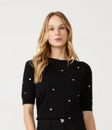 Blusa de punto negra con escote redondo, manga corta y apliques de corazones dorados.