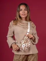 Riñonera con estampado animal print, cierre superior con cremallera y correa blanca regulable.