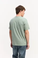 Remera blanca de manga corta y cuello redondo, confeccionada en algodón, con estampa frontal geométrica y tipográfica multicolor.