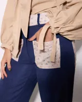 Pantalon de pana azul marino con corte semi oxford, presenta paneles laterales y bolsillos frontales con estampado floral en tonos beige.