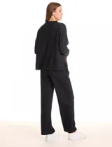 Buzo deportivo de cuello redondo, con hombros caídos y mangas largas con puños. Presenta costuras decorativas tipo pespunte en la parte frontal y en las mangas, con un diseño de ruedo recto y tajos laterales.