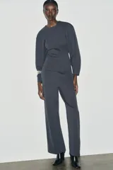 Pantalón de tiro alto con corte ancho y recto, confeccionado en tejido de punto elástico y flexible con cintura elástica.