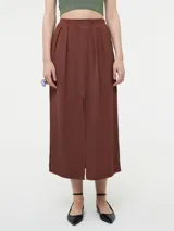 Falda marrón de corte midi con tajo frontal, pretina elastizada en la parte trasera y pinzas delanteras.