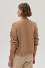 Cárdigan color camel de tejido de punto con trenzas en las mangas y cierre frontal con botones.