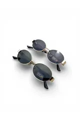 Lentes de sol Fuoco con armazón metálico dorado y formato ovalado. Cuenta con cristales oscuros y patillas anchas con terminaciones plásticas en color negro.