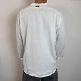 Camisa de manga larga con cuello mao, confeccionada en lino, con corte regular y cierre frontal de botones.