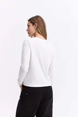 Remera de manga larga color gris oscuro, con cuello redondo y estampa gráfica frontal en tonos blancos y celestes con motivos florales y texto.