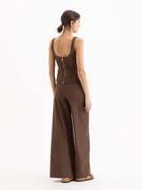Pantalón wide leg color beige, de tiro medio-alto, con elástico en la espalda y tajos en las botamangas. Incluye cinto con hebilla del mismo tono y pinzas traseras.