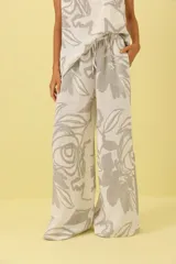 Pantalón palazzo de lino color crudo con estampado floral en tonos grises.