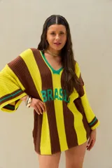 Remerón tejido de punto oversize, con diseño a rayas verticales marrones y amarillas, escote en V con ribete verde y la palabra "BRASIL" estampada en el frente.