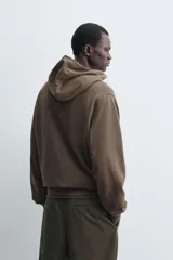 Sudadera tipo hoodie de corte regular, confeccionada en tejido de algodón ligero. Presenta cuello con capucha, manga larga y terminaciones en rib en puños y ruedo. Posee un acabado de aspecto lavado con tintado especial.