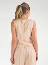 Chaleco sastrero de lino color beige con diseño de rayas verticales, escote en V y cierre frontal con botones.