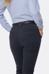 Pantalón largo de gabardina elastizada color azul marino, corte skinny, con bolsillos delanteros y traseros, y presillas para cinturón.