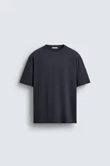 Camiseta de corte relajado confeccionada en algodón con textura irregular, cuello redondo y manga corta.