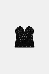 Top de terciopelo negro con escote corazón y aplicación de brillos en toda la superficie.