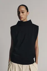 Top negro de hilatura de algodón, sin mangas y con cuello subido. Cuenta con cierre en la espalda mediante botones a presión.
