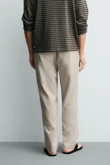 Pantalón de corte regular fit confeccionado en tejido mezcla de algodón, con cintura elástica ajustable mediante cordón, bolsillos laterales y bolsillos traseros de vivo.