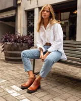 Botinetas de cuero color marrón con paneles laterales de gamuza en tono más oscuro y suela track negra de goma.