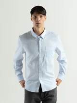 Camisa celeste con estampado a cuadros blancos, de manga larga y corte clásico.