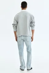 Jean de cinco bolsillos en denim de algodón con lavado claro y leve efecto desteñido. Modelo de cintura clásica, con cierre frontal y corte recto de pierna holgada.