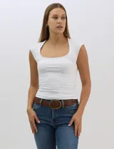Musculosa de calce entallado confeccionada en tejido de punto elástico. Presenta un escote cuadrado amplio y profundo, con mangas japonesas cortas y espalda cerrada.