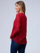 Blusa de encaje roja, marca Adiva. Cuello a la base, escote en V y apertura con botones. Manga larga con puño y botones. Incluye musculosa interna.