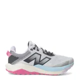 Championes de trail running New Balance Nitrel v6, con capellada de malla técnica en color gris claro y detalles en lila, celeste y fucsia. Presenta el logo N en los laterales, mediasuela con amortiguación y suela AT Tread para mayor tracción.