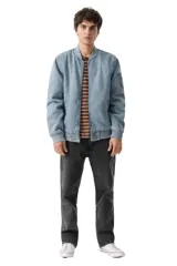 Campera tipo bomber confeccionada en denim lavado, con cierre frontal, cuello, puños y ruedo en tejido rib elástico. Presenta bolsillos laterales y un bolsillo utilitario con cierre en la manga izquierda.