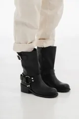 Bota de cuero negra de caña media con hebillas metálicas y taco bajo.