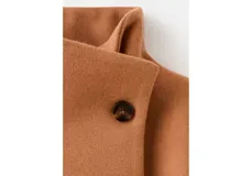 Campera corta de paño color tostado, con cuello alto, cierre frontal cruzado con botones y bolsillos laterales con solapa.