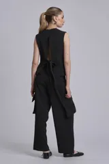 Chaleco negro con escote en V y cierre frontal con botones.