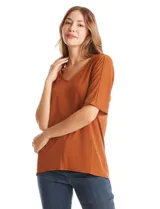 Blusa de silueta fluida con escote en V, manga japonesa corta y costura central vertical en el frente. Confeccionada en tejido de punto con acabado mate, presenta un diseño con largo asimétrico, siendo más larga en la espalda.